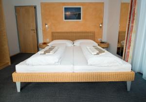 a large bed with white sheets and pillows on it at Apart Primavera in Samnaun