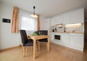 a kitchen with a table and chairs in a room at Apart Primavera in Samnaun