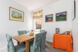 comedor con mesa de madera y sillas en JOIVY Charming 3 bed house with a rooftop terrace, en Londres