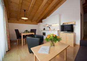 a living room with a table with a vase of flowers on it at Apart Primavera in Samnaun