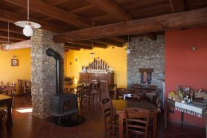 a restaurant with tables and chairs and a wood stove at Agriturismo A Nostro Mizoun in Ostana