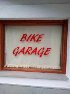 un cartello per il garage delle biciclette sul lato di un edificio di Casa Screm - Appartamenti e Camere a Rigolato