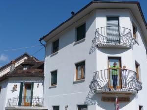 2 persone su un balcone di un edificio di Casa Screm - Appartamenti e Camere a Rigolato