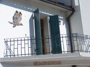 un uccello seduto su un balcone di un edificio di Casa Screm - Appartamenti e Camere a Rigolato