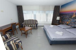 ein Hotelzimmer mit 2 Betten und einem Stuhl in der Unterkunft City Hotel Wuppertal in Wuppertal