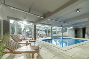 un patio al aire libre con sillas y una piscina en Aguila Mora Suites & Spa en San Carlos de Bariloche