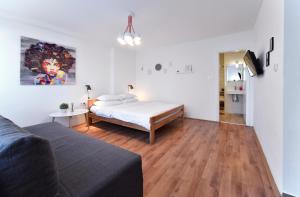 ein Schlafzimmer mit einem Bett und einem Sofa in einem Zimmer in der Unterkunft Vla Vla Apartments, Zagreb City Center in Zagreb