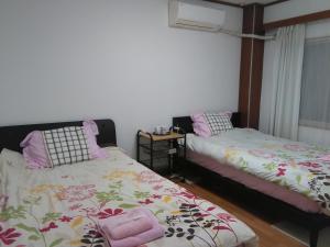 1 dormitorio con 2 camas y ventana en Osaka Kuma House, en Osaka