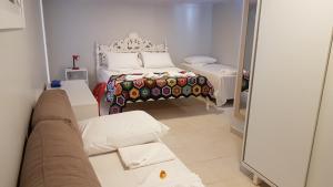 1 dormitorio con cama, sofá y espejo en Pousada das Bromélias en Porto De Galinhas