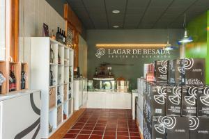 a restaurant with a shelf of wine bottles at Bodega-Enoturismo Lagar De Besada in Xil