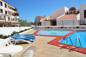 a swimming pool with chairs and a table and a table and a tablektopktop at FN FUNCHAL Tenerife 101 in El Guincho