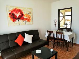 a living room with a couch and a dining room table at FN FUNCHAL Tenerife 101 in El Guincho