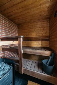 een houten sauna met een bank en een fornuis bij Jokiniemen Matkailu Cottages in Tölvä