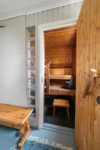 uma pequena sauna com um banco e uma mesa em Jokiniemen Matkailu Cottages em Tölvä