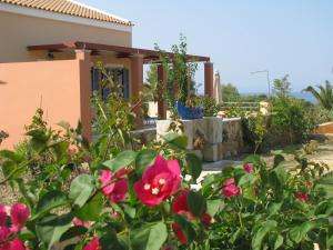 una casa con un jardín con flores rosas en Remetzo Village en Lixouri