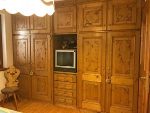 a living room with wooden cabinets and a tv at Sweet Home in Cortina dʼAmpezzo