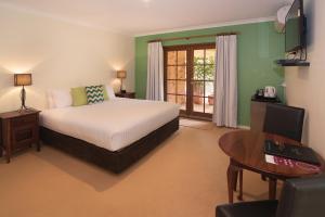 a bedroom with a bed and a desk and a table at Pinda Lodge in Margaret River Town