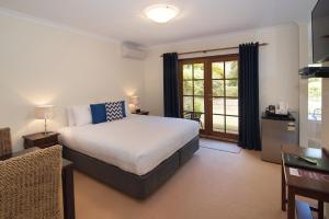 a bedroom with a large bed and a window at Pinda Lodge in Margaret River Town