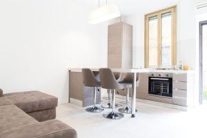 a living room with a table and chairs and a couch at Brand, new and fully furnished apt in Milan