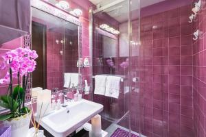 ein rosafarbenes Bad mit einem Waschbecken und einem Spiegel in der Unterkunft Diana Luxury Loft in Rom