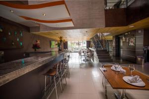 um restaurante com um bar com mesas e cadeiras em Hotel Golden Palermo em Medellín