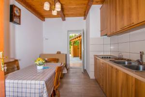 a kitchen with a table and a sink at APARTMAN ŠARE in Crikvenica