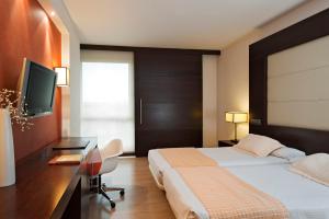 a hotel room with a bed and a desk at Eurostars i-hotel Madrid in Pozuelo de Alarcón