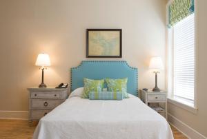 a bedroom with a blue bed with two night stands at Kings Courtyard Inn in Charleston