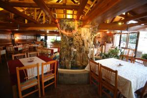 a restaurant with tables and a large tree in the middle at Hotel Pasarela in Berat