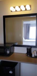 a bathroom with a mirror and a counter with a sink at Econo Lodge Inn & Suites in Abilene