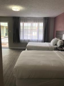 a hotel room with two beds and a window at Econo Lodge Inn & Suites in Abilene