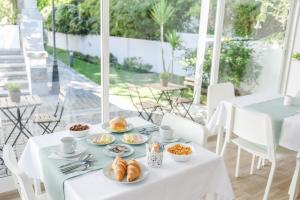 a white table with plates of food on it at 4U Lisbon VI Guesthouse Airport in Lisbon