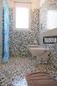 bagno con lavandino, servizi igienici e finestra di Villa Graziella a Ostuni