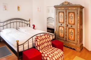 a bedroom with a bed and a chair and a dresser at Boardinghouse Marienlinde in Telgte