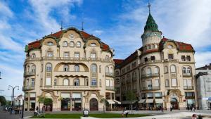 a large building with a clock tower on top of it at Cristi's Rooms - Pensiune in Oradea