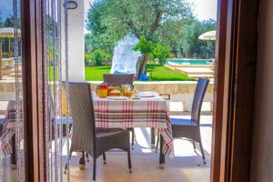 - une table et des chaises avec un ordinateur portable sur la terrasse dans l'établissement Villa Franchino, à Ostuni