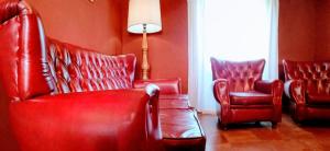 una sala de estar con muebles de cuero rojo y una lámpara. en Las Golondrinas, en Casiellas