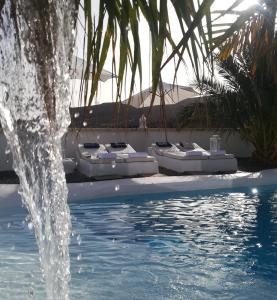 a fountain in front of a pool with beds at Villa Adriano in Sabina Alta