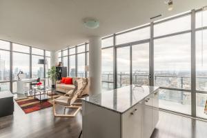 Unbelievable Penthouse View with 3 bedrooms في تورونتو: مطبخ وغرفة معيشة مع نوافذ كبيرة