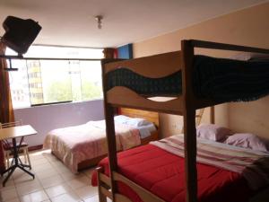 1 dormitorio con 2 literas y ventana en Hospedaje Centro en Huancayo