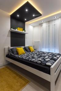 a large bed with yellow pillows in a room at Park Apartment in Novi Sad