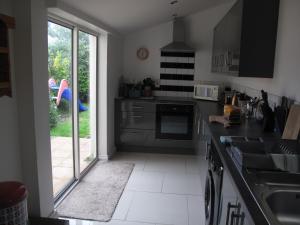 a kitchen with a sink and a door to a yard at Simon's Cosy House in Bangor