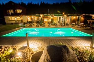 a swimming pool in a backyard at night at Chalet Schäfer s vyhřívaným bazénem se slanou vodou a saunou in Harrachov