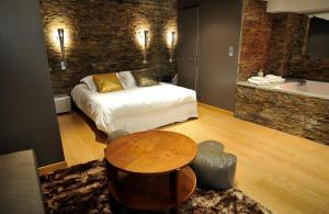 1 dormitorio con cama, mesa y bañera en Le Gourguillon, en Lyon