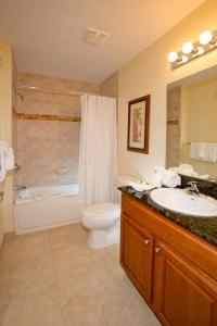 a bathroom with a toilet a sink and a bathtub at Lake Buena Vista Resort Village and Spa, a staySky Hotel & Resort Near Disney in Orlando