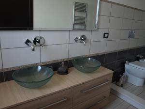un baño con 2 cuencos verdes en una encimera en A Due Passi Da Tutto, en Catania
