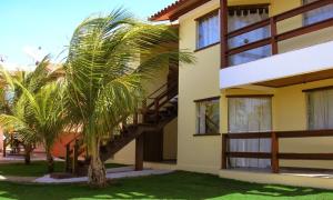 a palm tree in front of a building with a staircase at Residence Paraíso in Porto Seguro