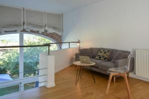 ein Wohnzimmer mit einem Sofa und einem Tisch mit einem Laptop in der Unterkunft L'Abelli d'Estelle in Le Touvet