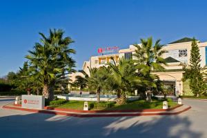 un hôtel avec des palmiers devant un bâtiment dans l'établissement Ramada Plaza by Wyndham Tunis, à Gammarth