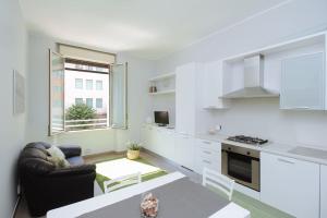 una cucina bianca con divano e tavolo di Spacious and new apt in Città Studi a Milano